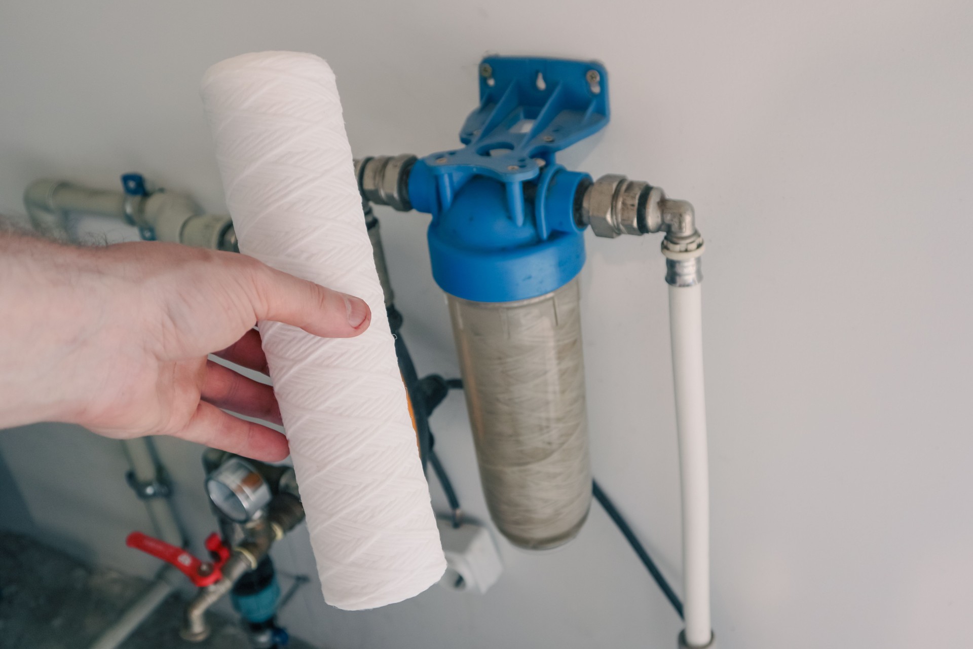 Plumber change water filter. Replacement aqua filter. Technician maintenancing system of water filtration.